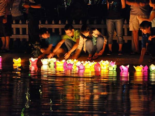 туристы пускают фонарики по реке